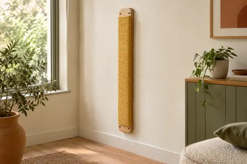 Griffoir mural vertical jaune en jute et bois d’hévéa fixé sur un mur crème.