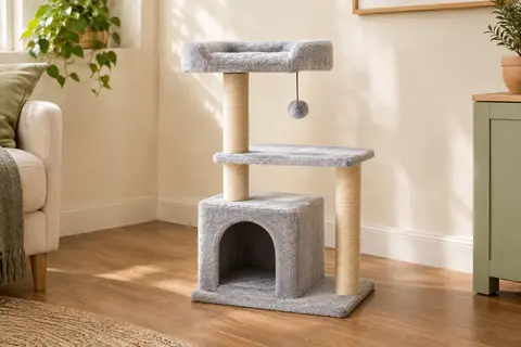 Arbre à chat gris clair avec cachette, perchoir, poteaux en sisal et boule suspendue dans un intérieur lumineux.